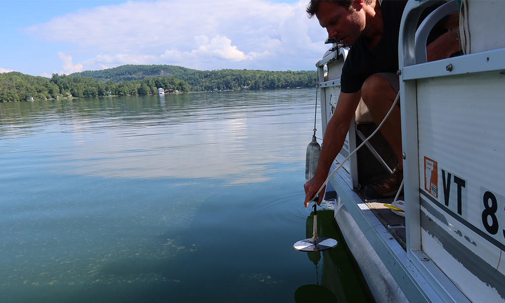 Mark Mitchell uses a secchi disk to measure water clarity in Lake Morey